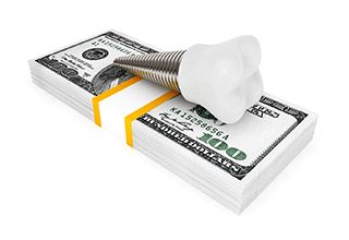 implant on money stack representing the cost of dental implants in Owasso 