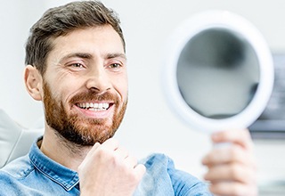 Young man admiring his new dental implants in Owasso 