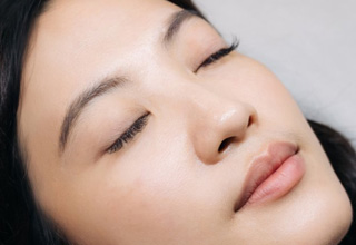 a woman closing her eyes and showing long eyelashes