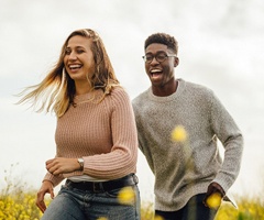 friends laughing and running through a field