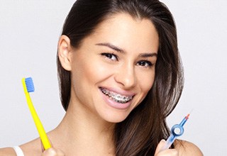 Woman with braces holding a toothbrush
