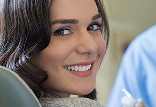 woman smilng over shoulder close to camera