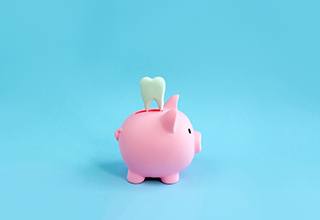 A pink piggy bank and decorative tooth on a blue background