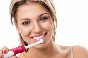 Woman using an electric toothbrush