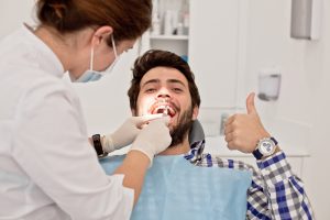 man plaid shirt smiling dentist chair