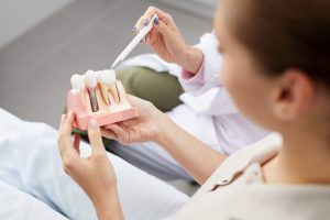 Woman holding dental implant in Owasso