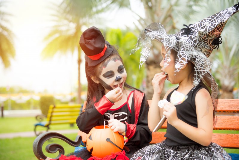 children eating Halloween candy on bench