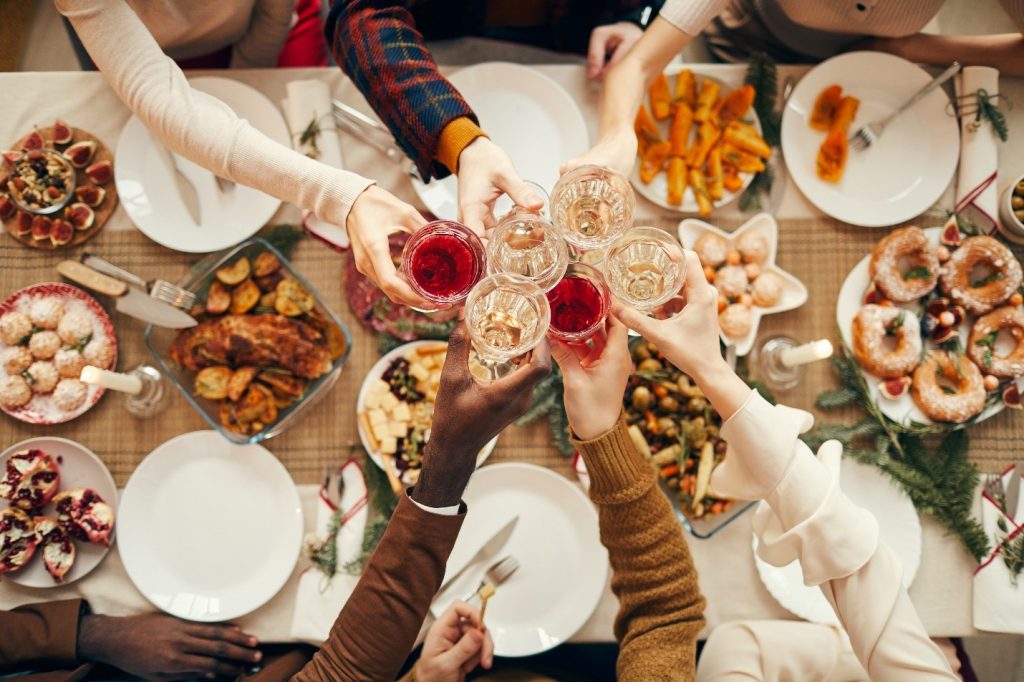 Friends toasting over an array of holiday foods