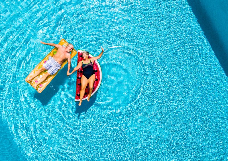 Elderly couple floating in pool