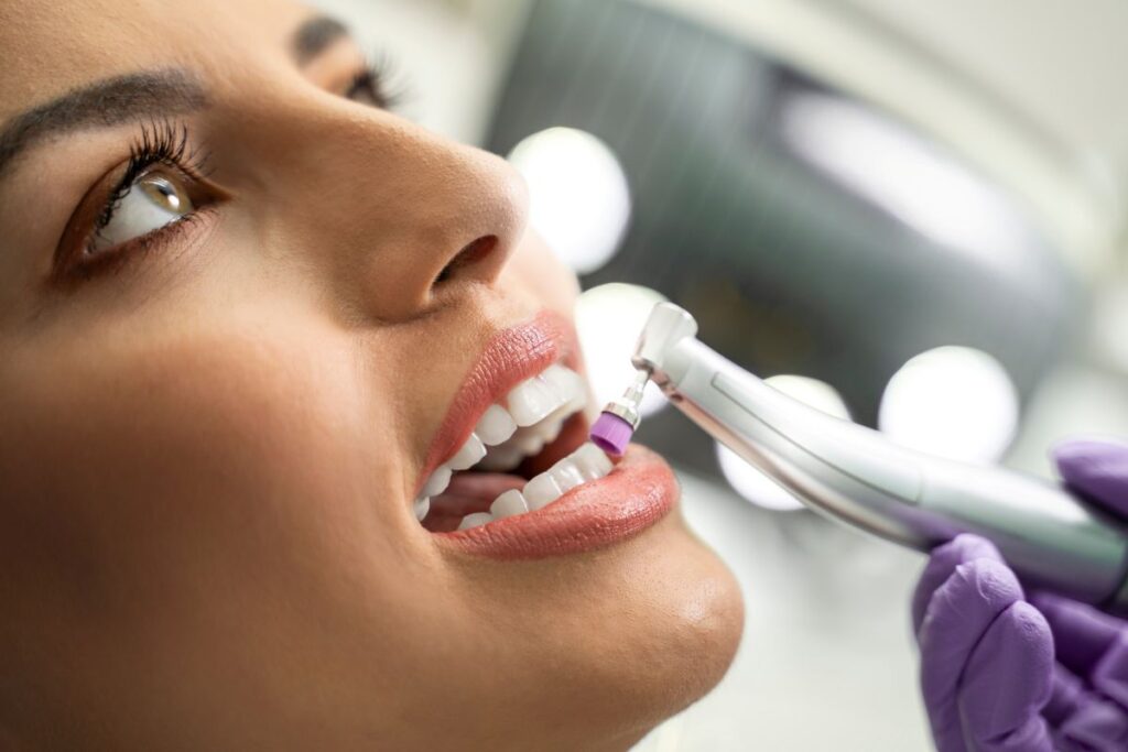 A woman getting her teeth cleaned by a dentist